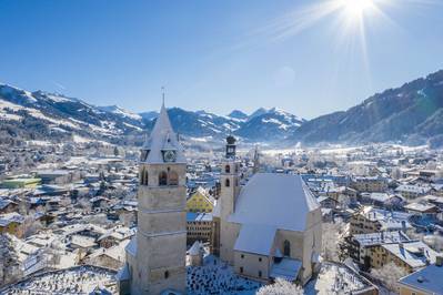 Blick auf das verschneite Kitzbühel, Winterstimmung mit wolkenlosem Himmel und Sonne