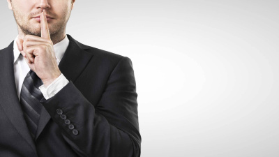 Mann mit Finger auf den Lippen, der um Schweigen bittet