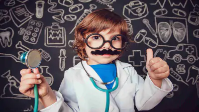 Kleines Kind in Arztkittel mit Stethoskop und Bart und Brille.
