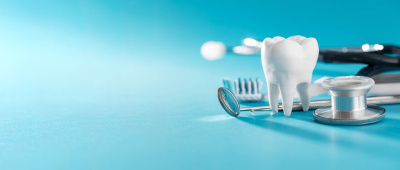 Weiße gesunde Zähne, verschiedene Werkzeuge für die Zahnpflege auf türkisenen Hintergrund