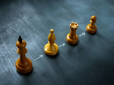Linie mit Schachfiguren und Pfeilen als Konzept der Nachfolgeplanung