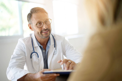 Arzt mit Stethoskop im Patientengespräch in einem medizinischen Büro