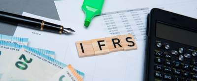 die Inschrift IFRS oder International Financial Reporting Standards neben einem Taschenrechner und Euro-Banknoten. Konzept der Rechnungslegung